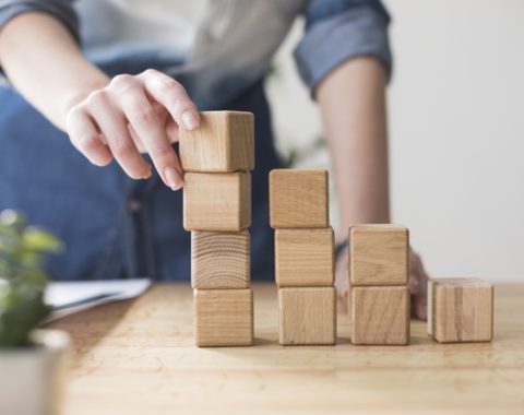 close-up-female-hand-stacking-wooden-block-desk-office_23-2148203931.jpg